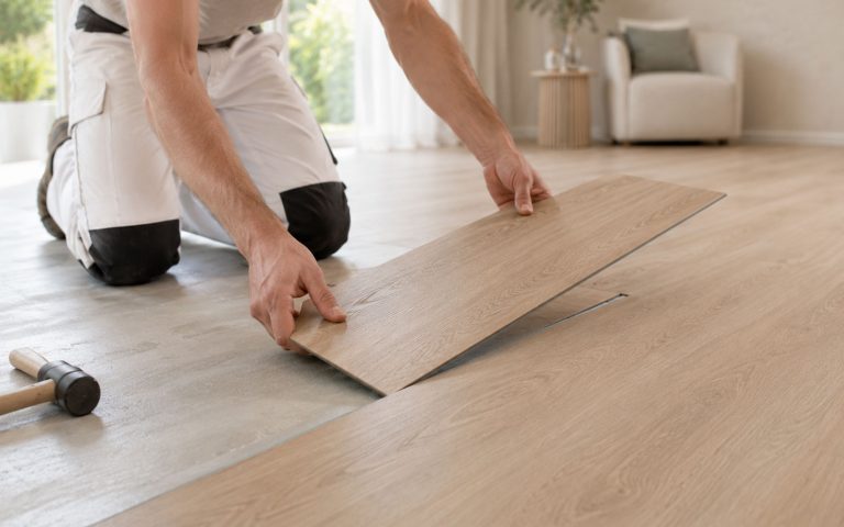Präzise Verlegung eines modernen Holzoptik-Bodens in einem hellen Wohnraum.